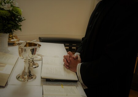 Billede af præst der beder ved alteret