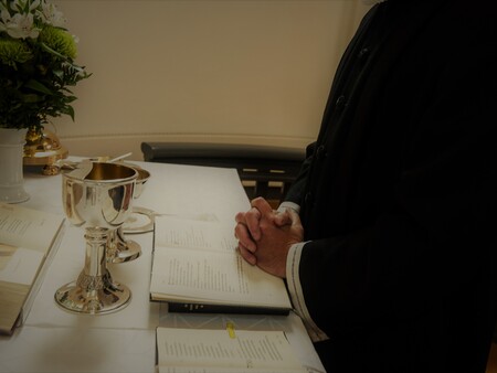 Billede af bibel og præst Billede af præst der beder ved alteret