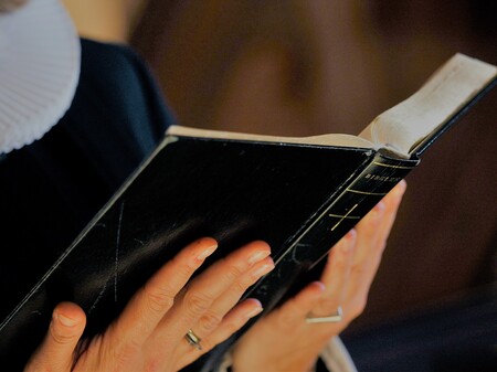 Oplæsning fra biblen Billede af præst, der læser fra Bibelen